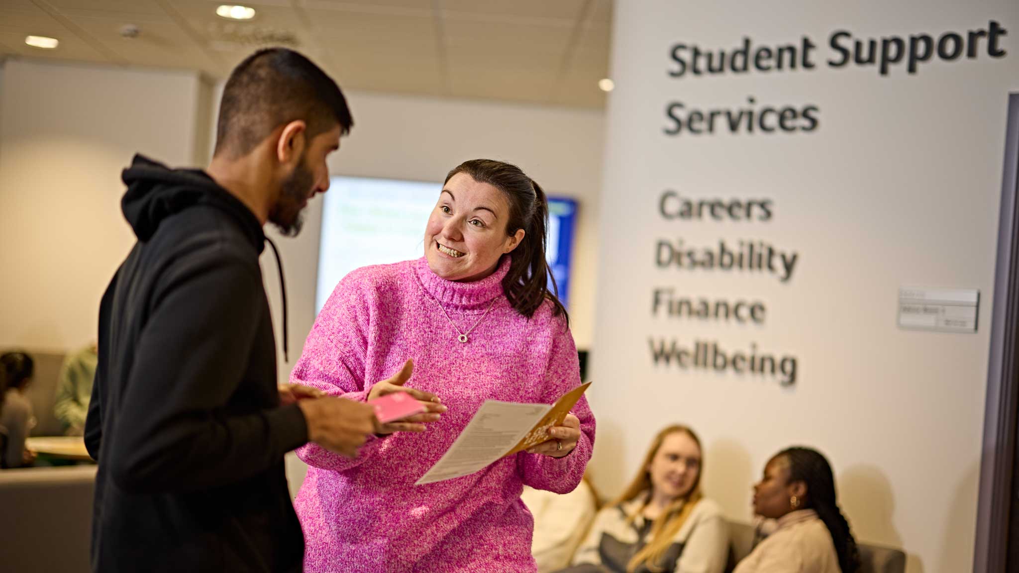 A student talking to a member of staff in student services