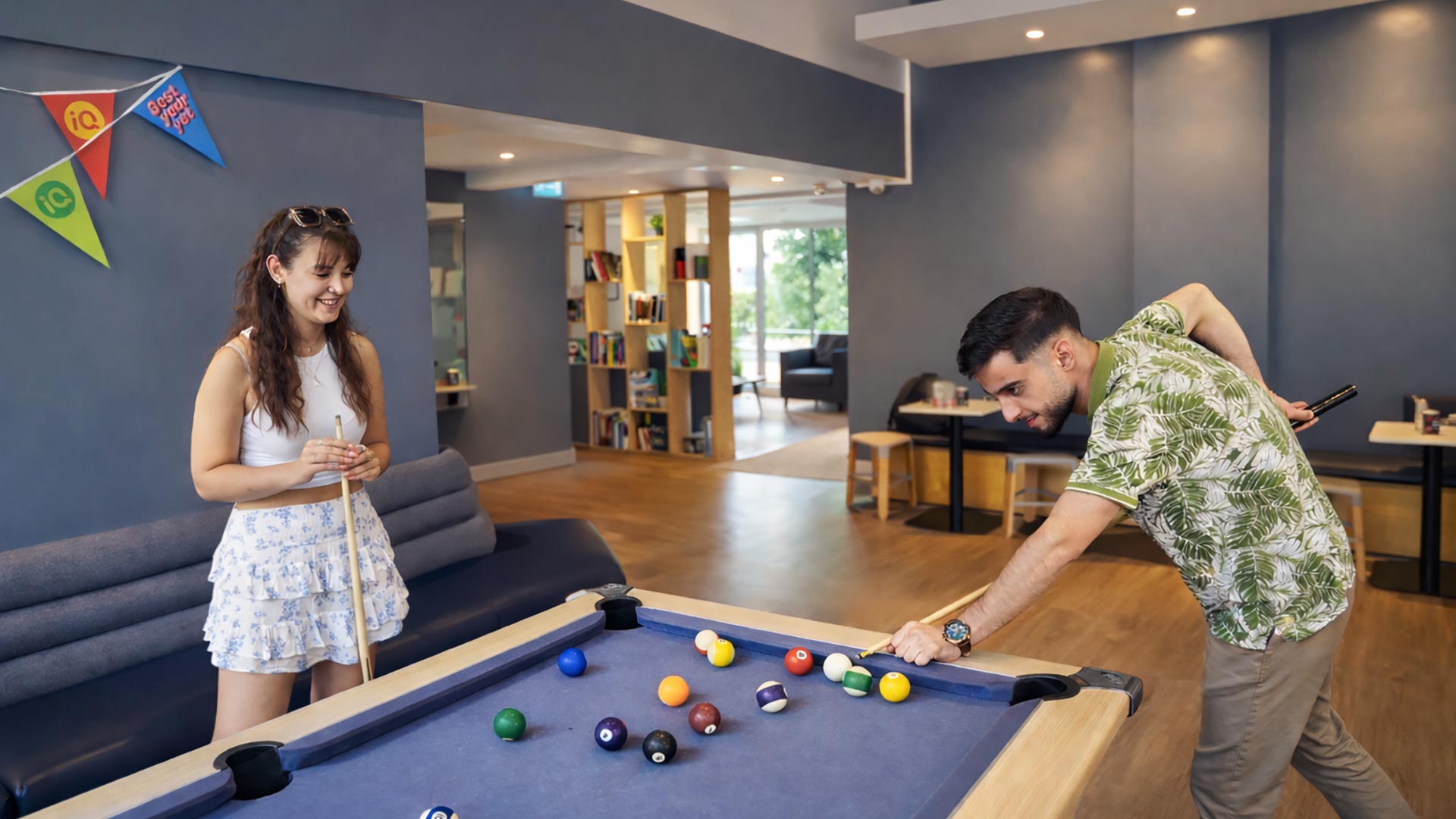 Two students playing pool in student accommodation.