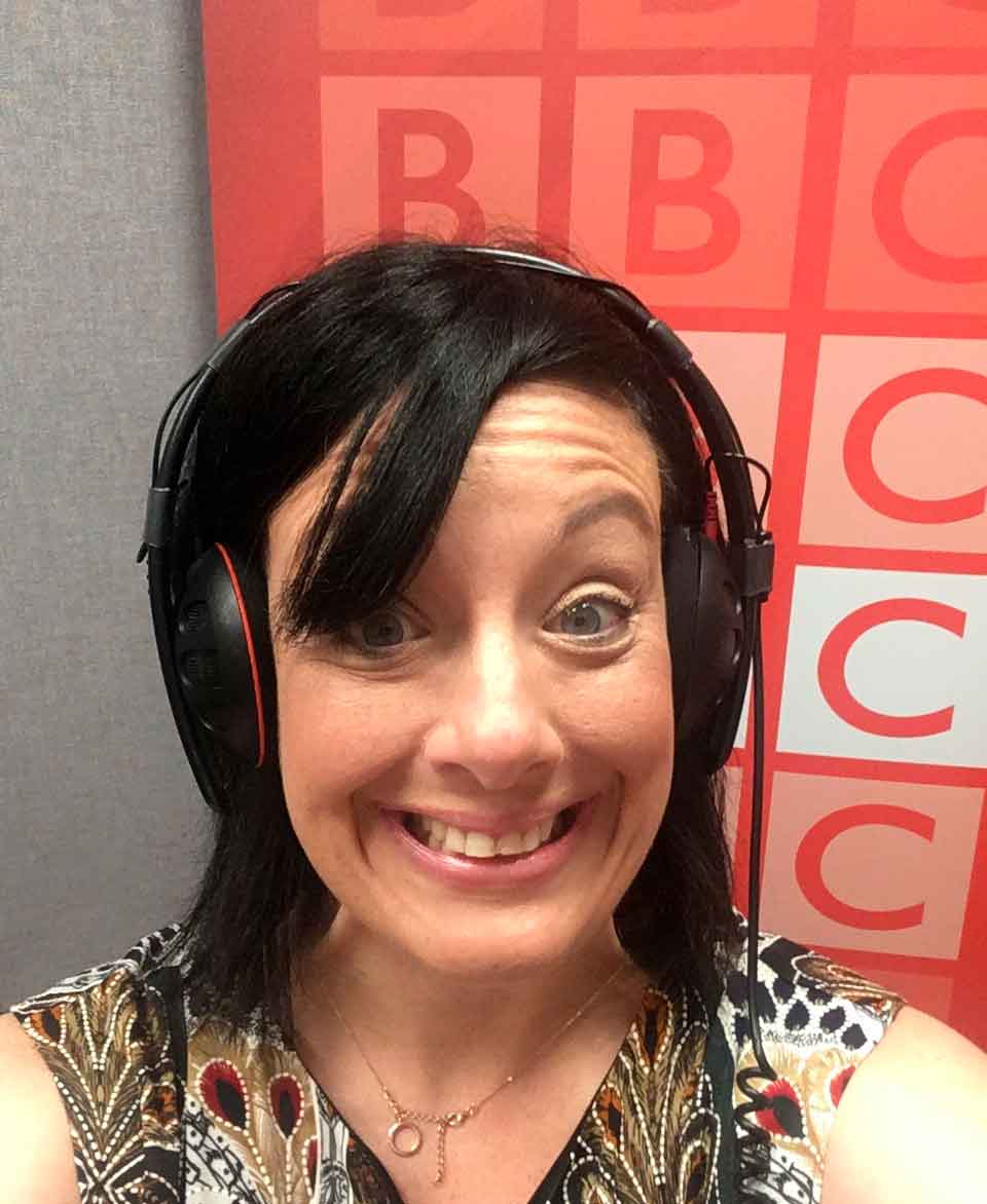 Teacher Joanne Pedelty in headphones with BBC backdrop