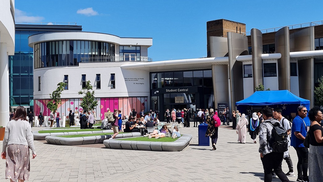 People walking in front of a white building against a blue sky