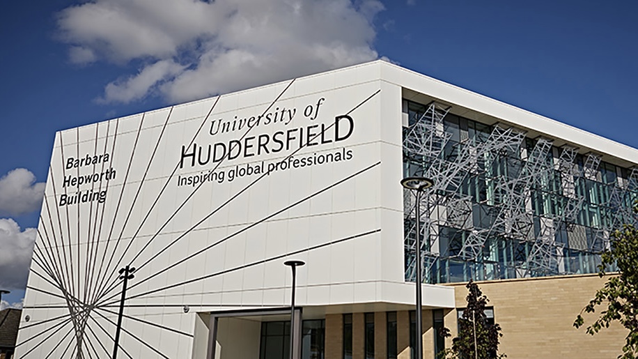 A modern university building with a white facade bearing the words Barbara Hepworth Building alongside the University of Huddersfield logo