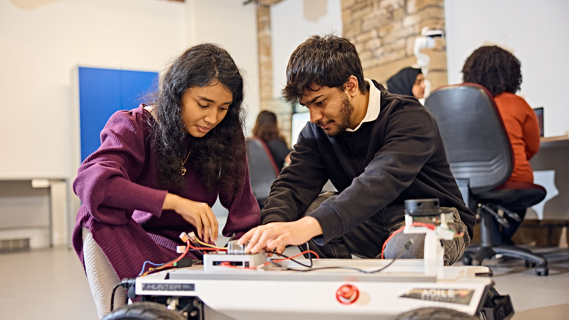 Two students building an AI machine