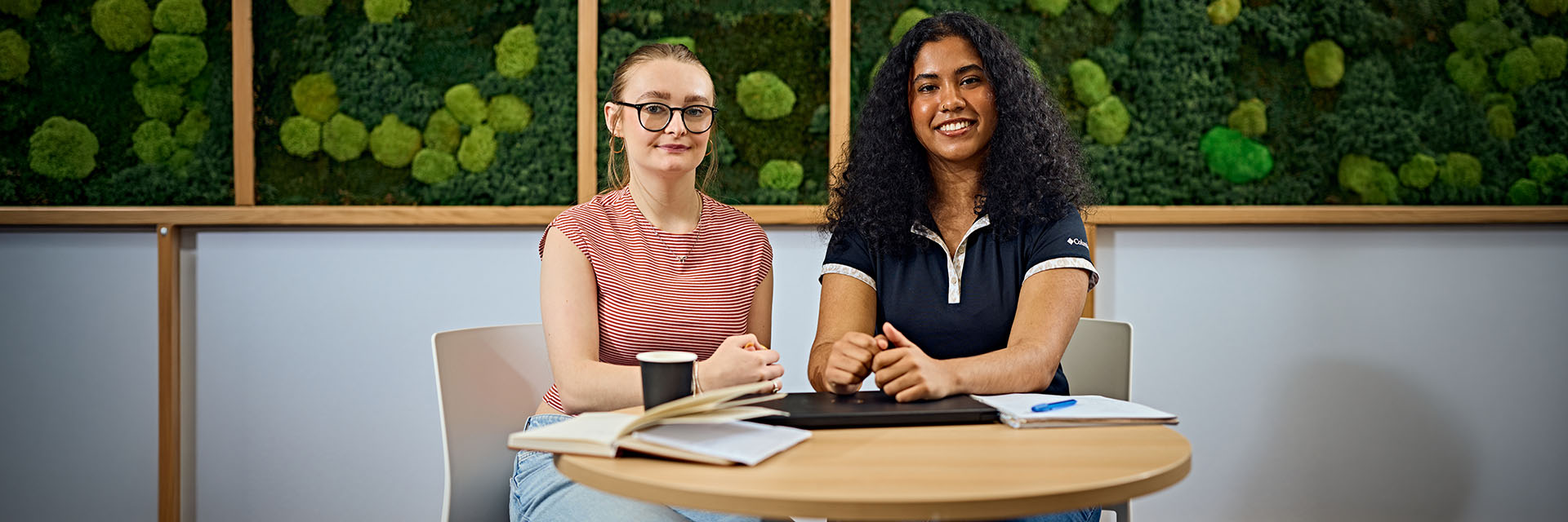 2 students smiling in a cafe