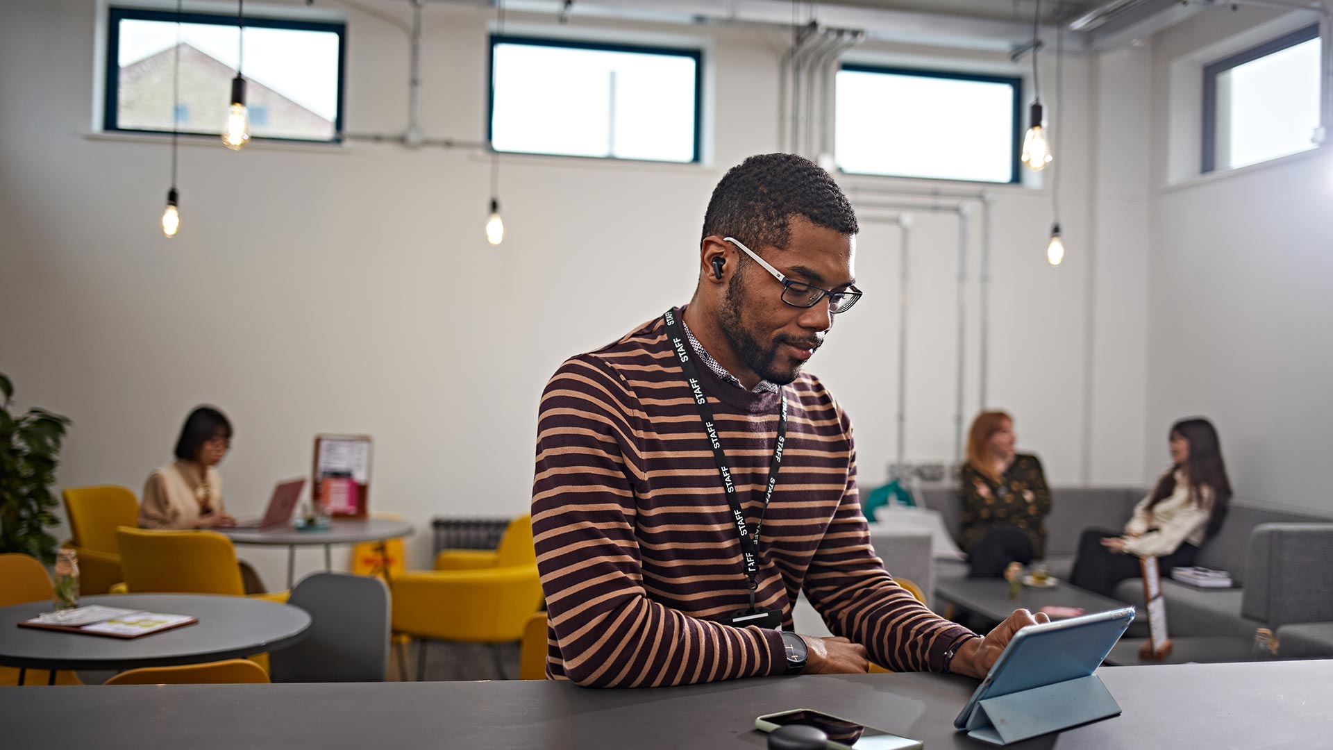 A working professional studying on their tablet in a cafe.