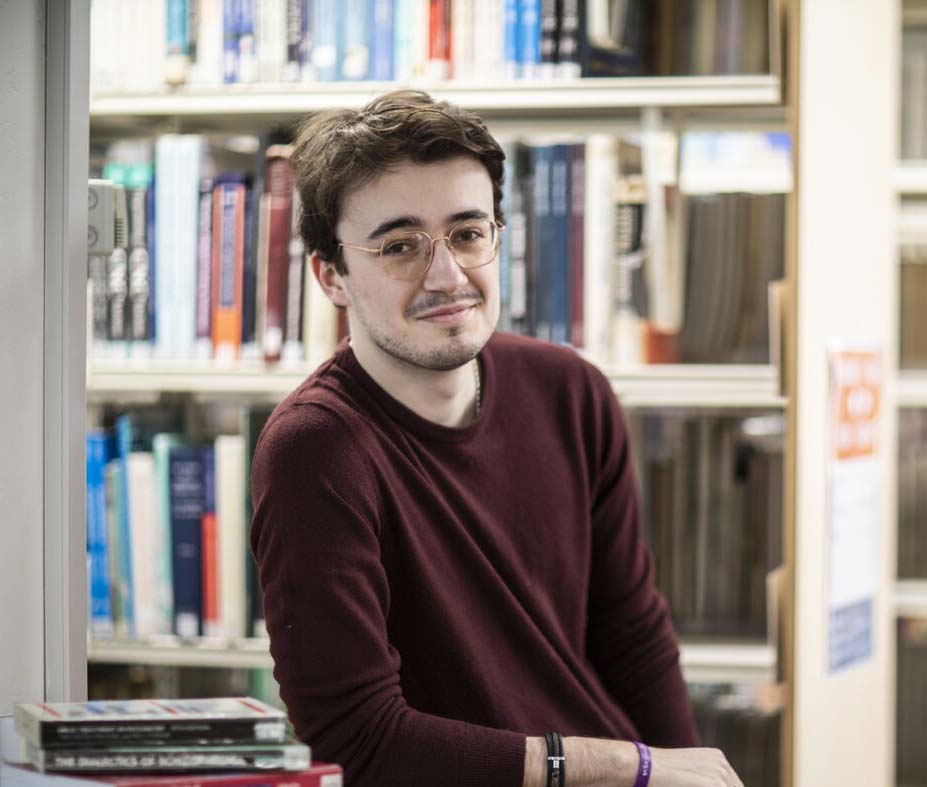 Tom Williams leaning on a table in the library