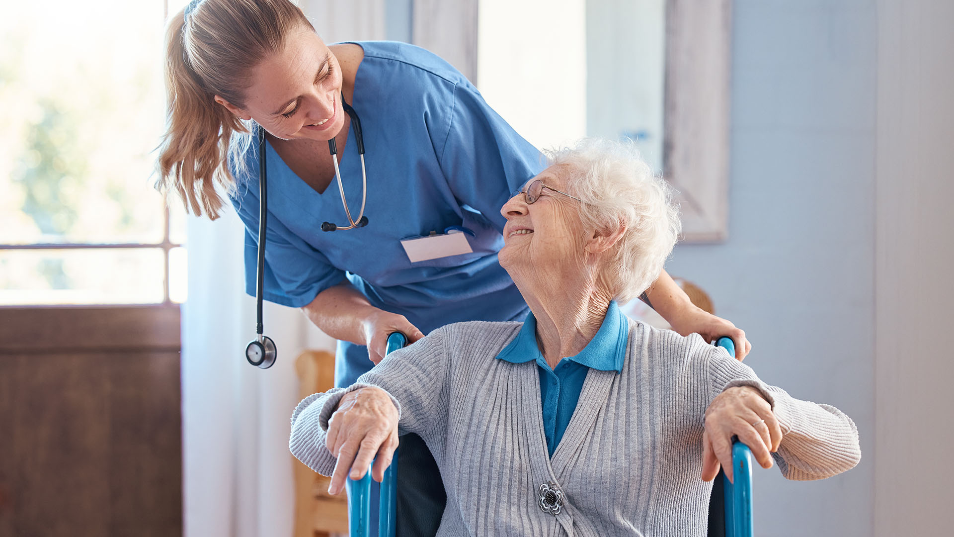 Old woman in wheelchair with a nurse