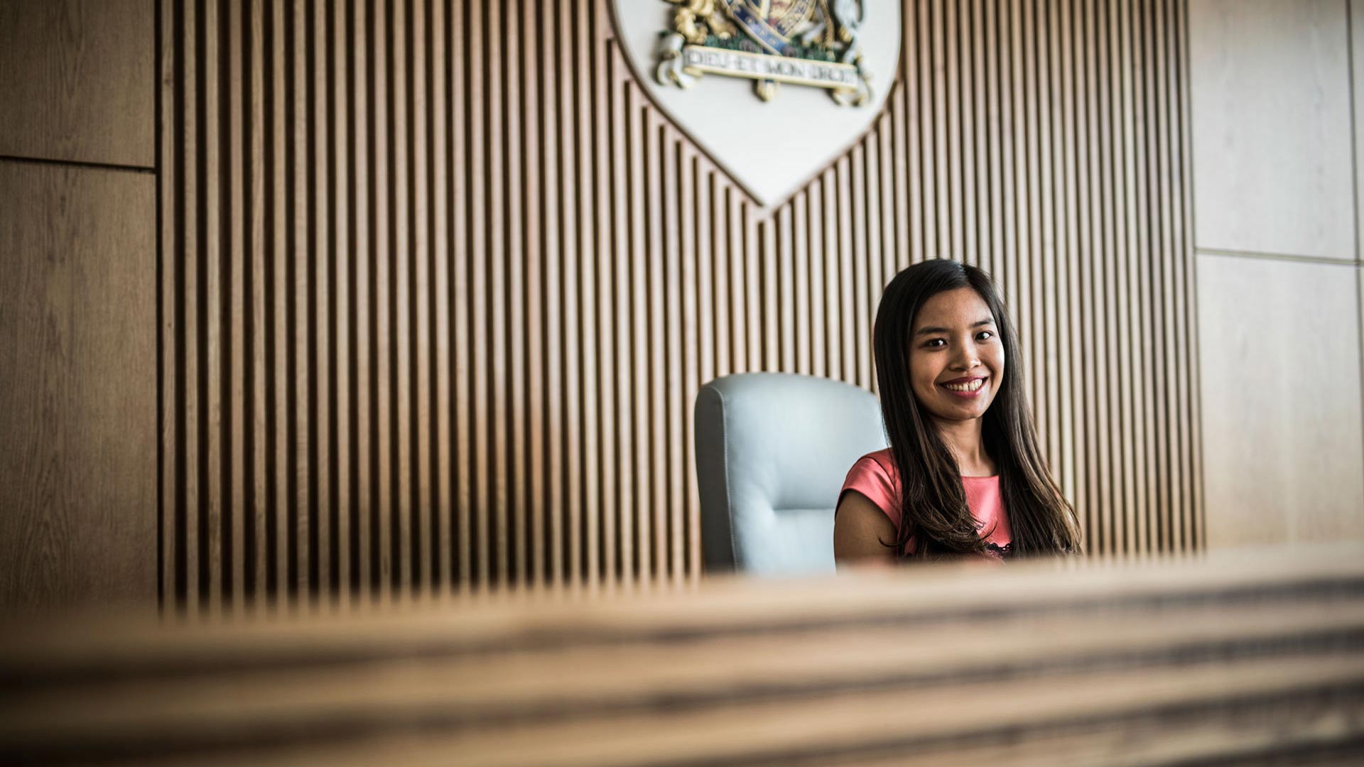 A student in The Oastler Building's Law Courtroom with The Royal Coat of Arms on the wall
