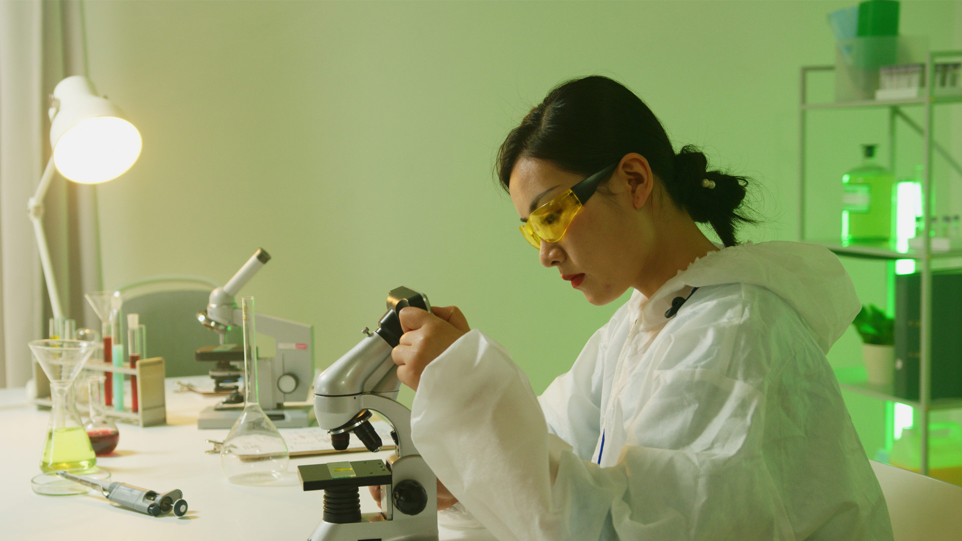 Biosciences student looking into microscope