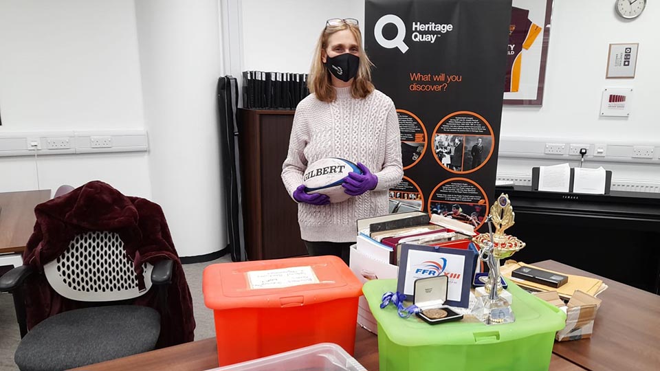 Julia Lee with rugby league items in an office