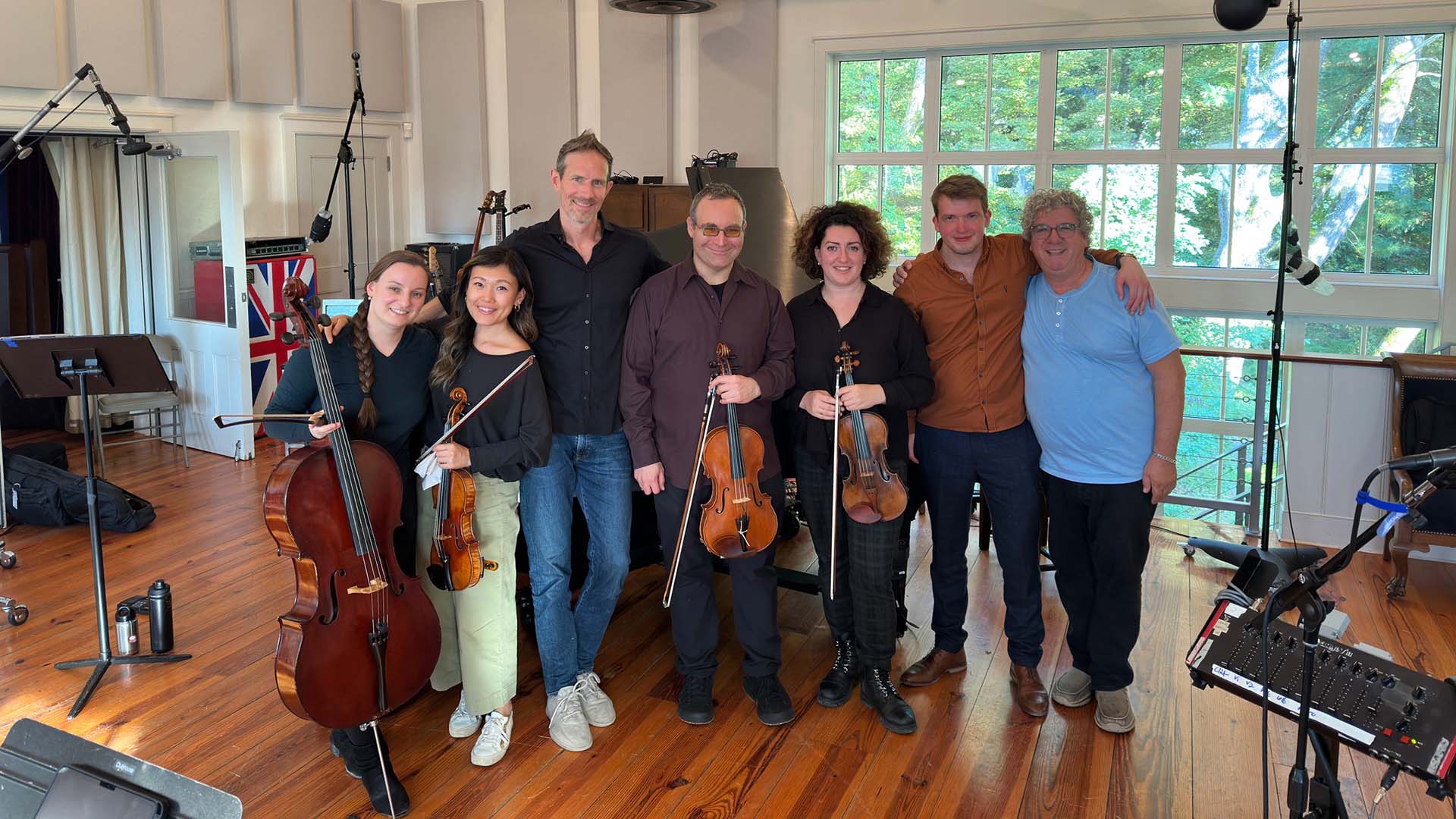 Musicians pose for a group photo on a recording studio