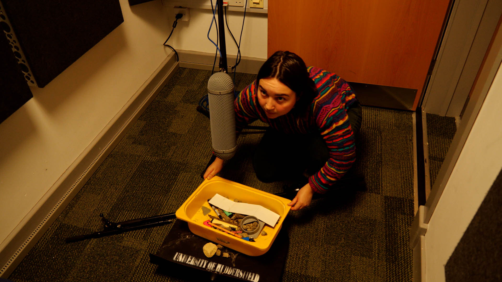 A technician sits with a tray of bolts and stones to create sound effects