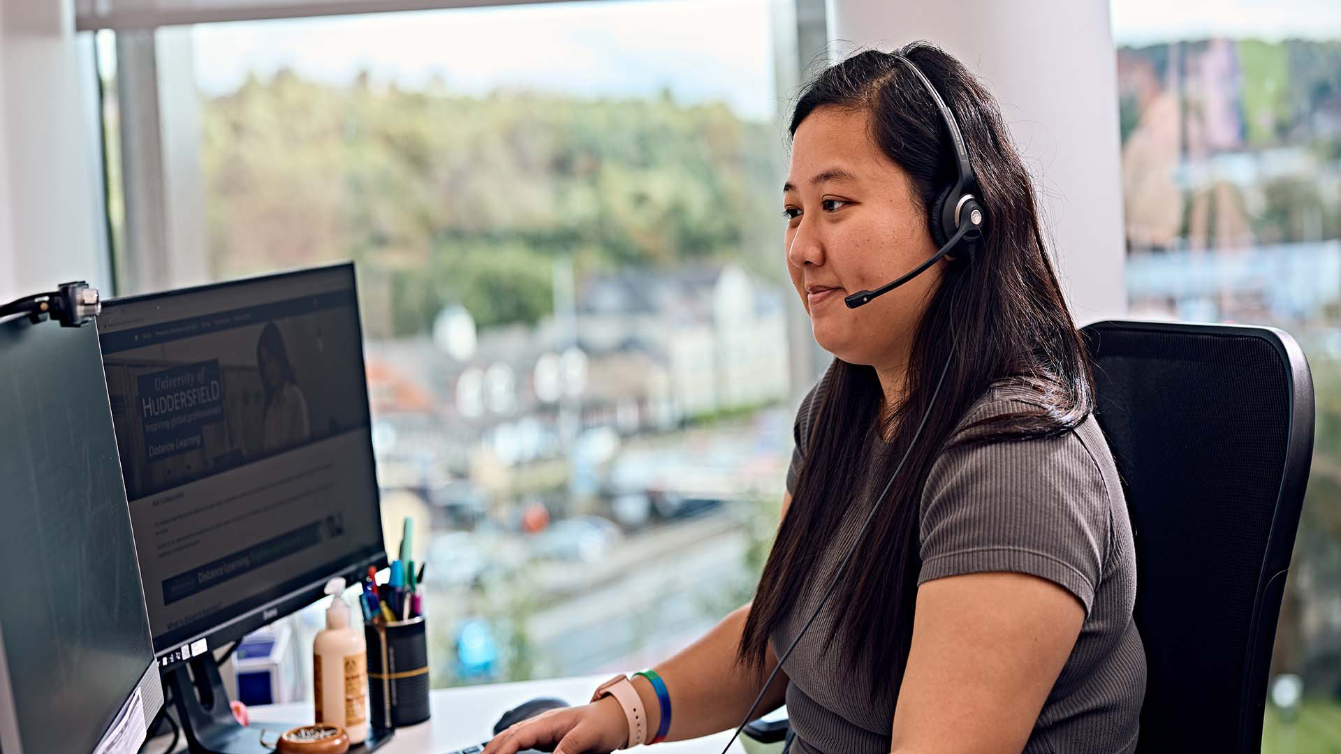 a student sat at a computer wearing headphone