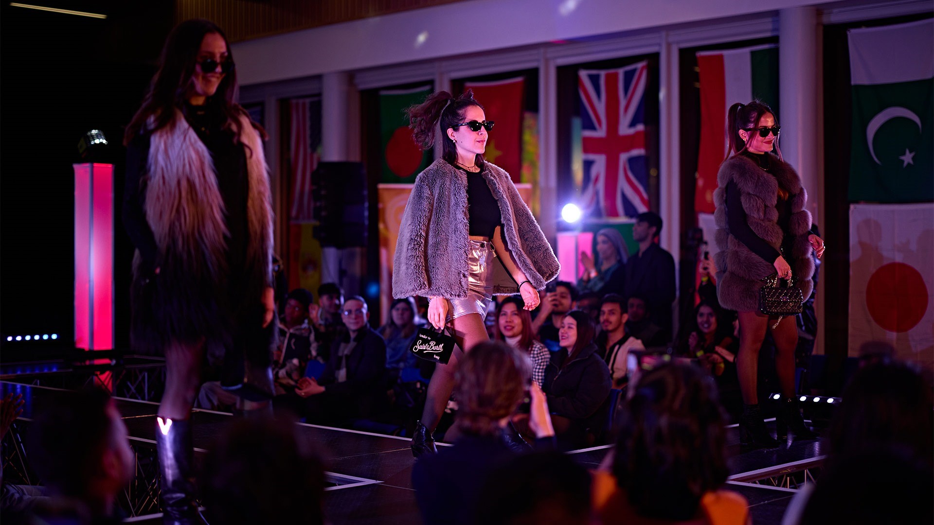 A woman walking on a catwalk in a fashion show