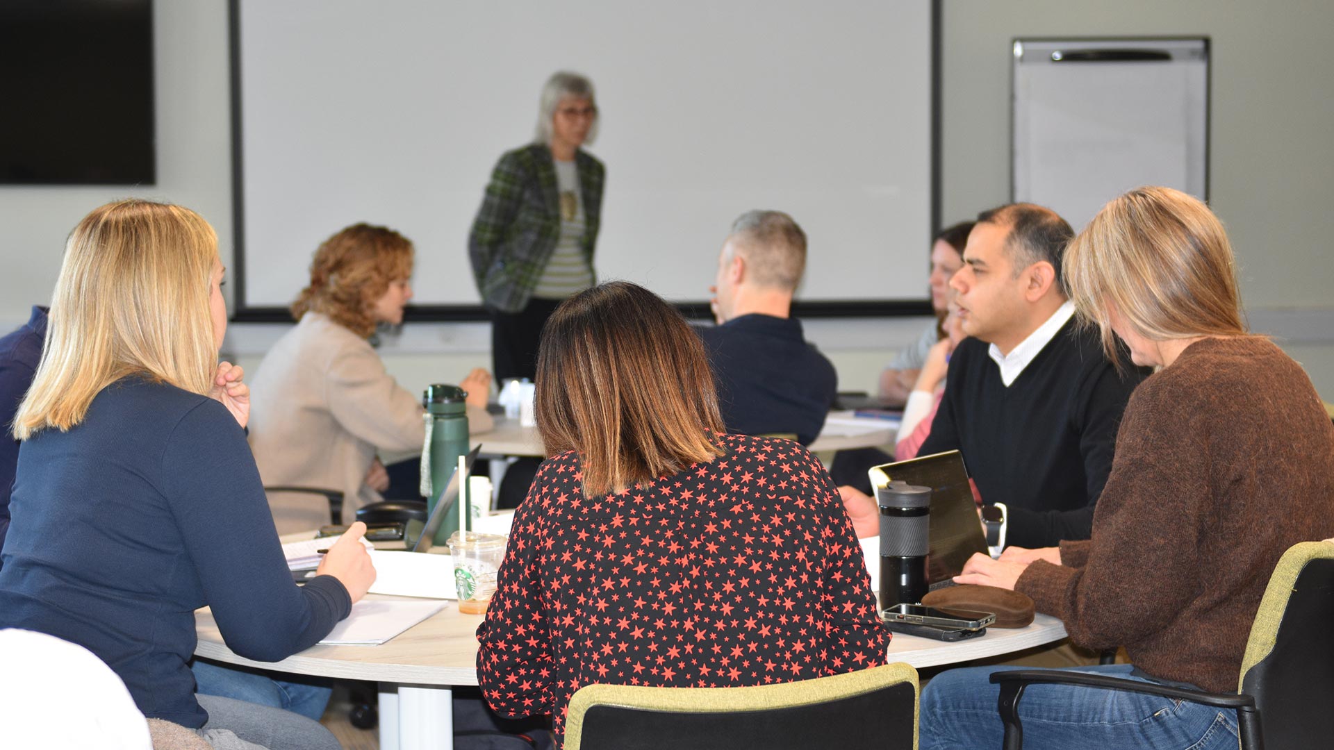 A group of people gathered round a table in a learning environment