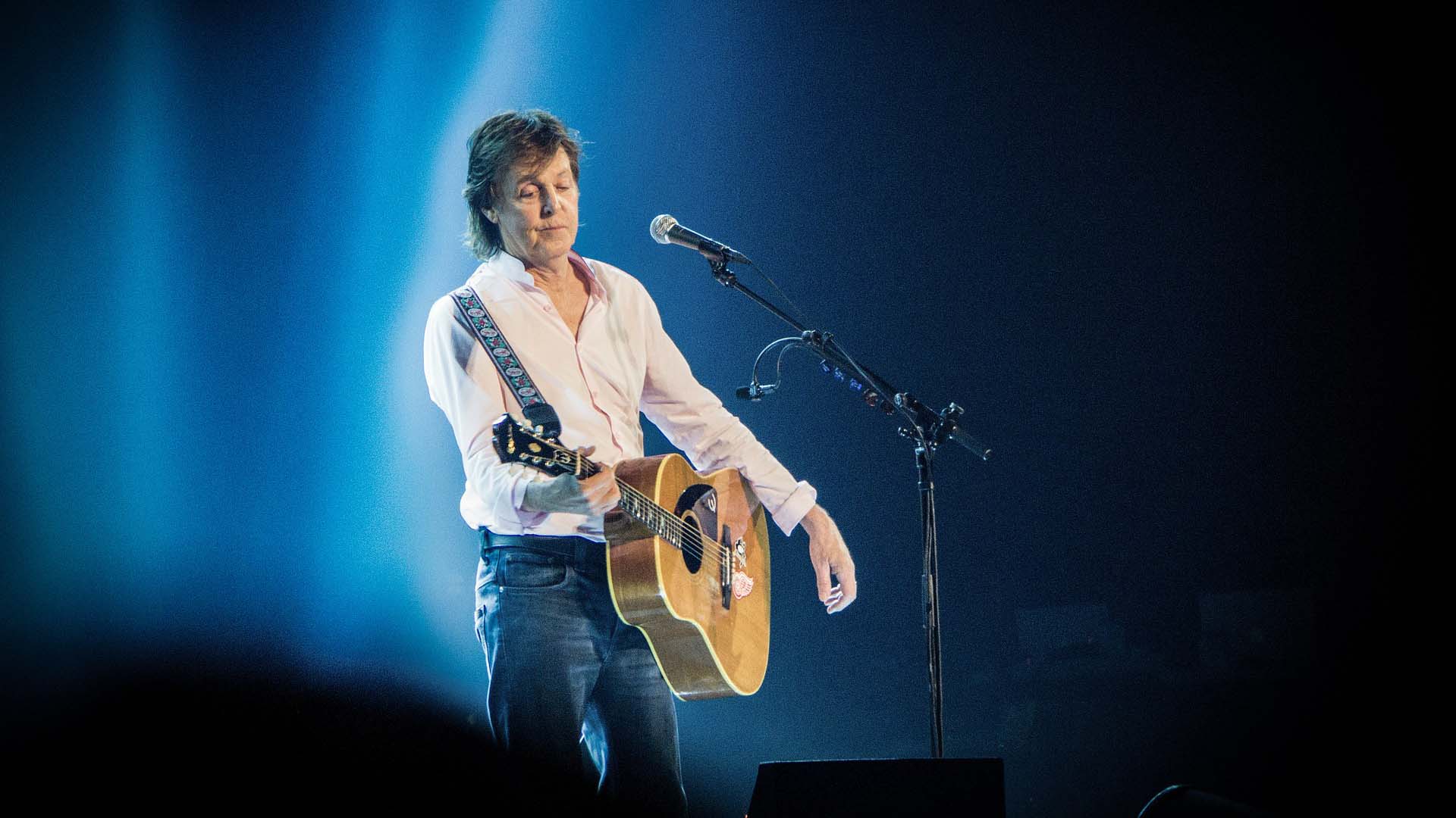 Paul McCartney plays his guitar