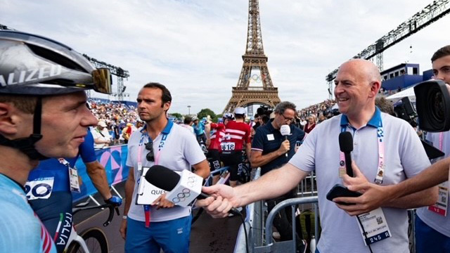 David Easson interviews a cyclist in front of the Eiffel Tower in Paris