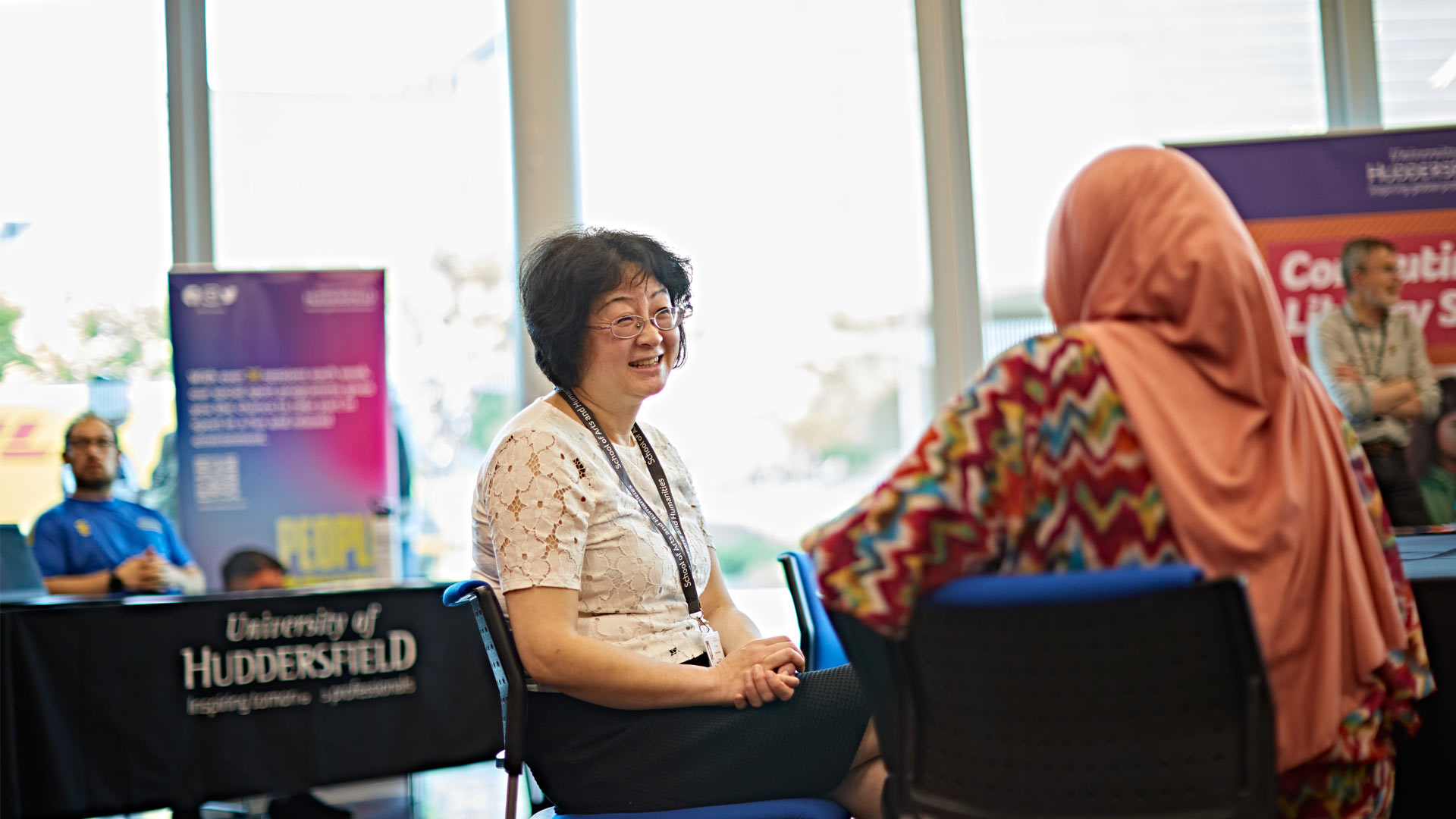 Staff and prospective postgraduate students chatting at open day event