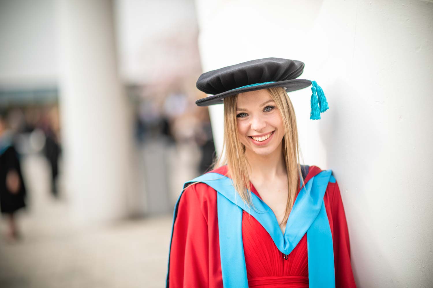 student in a graduation gown smiling
