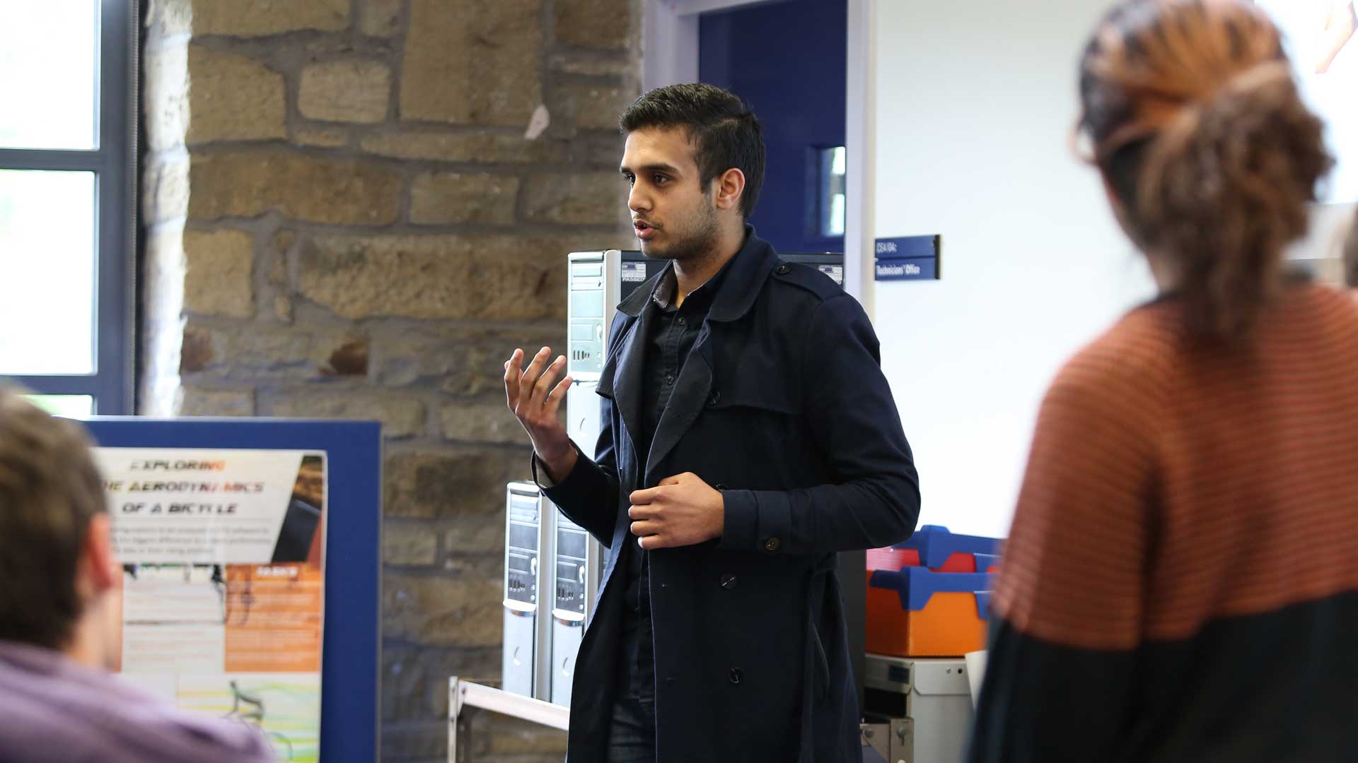 Photo of a researcher explaining their research at the FameLab