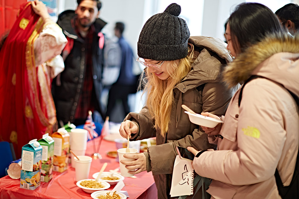 Two students getting food at the Bahrain National Day event.