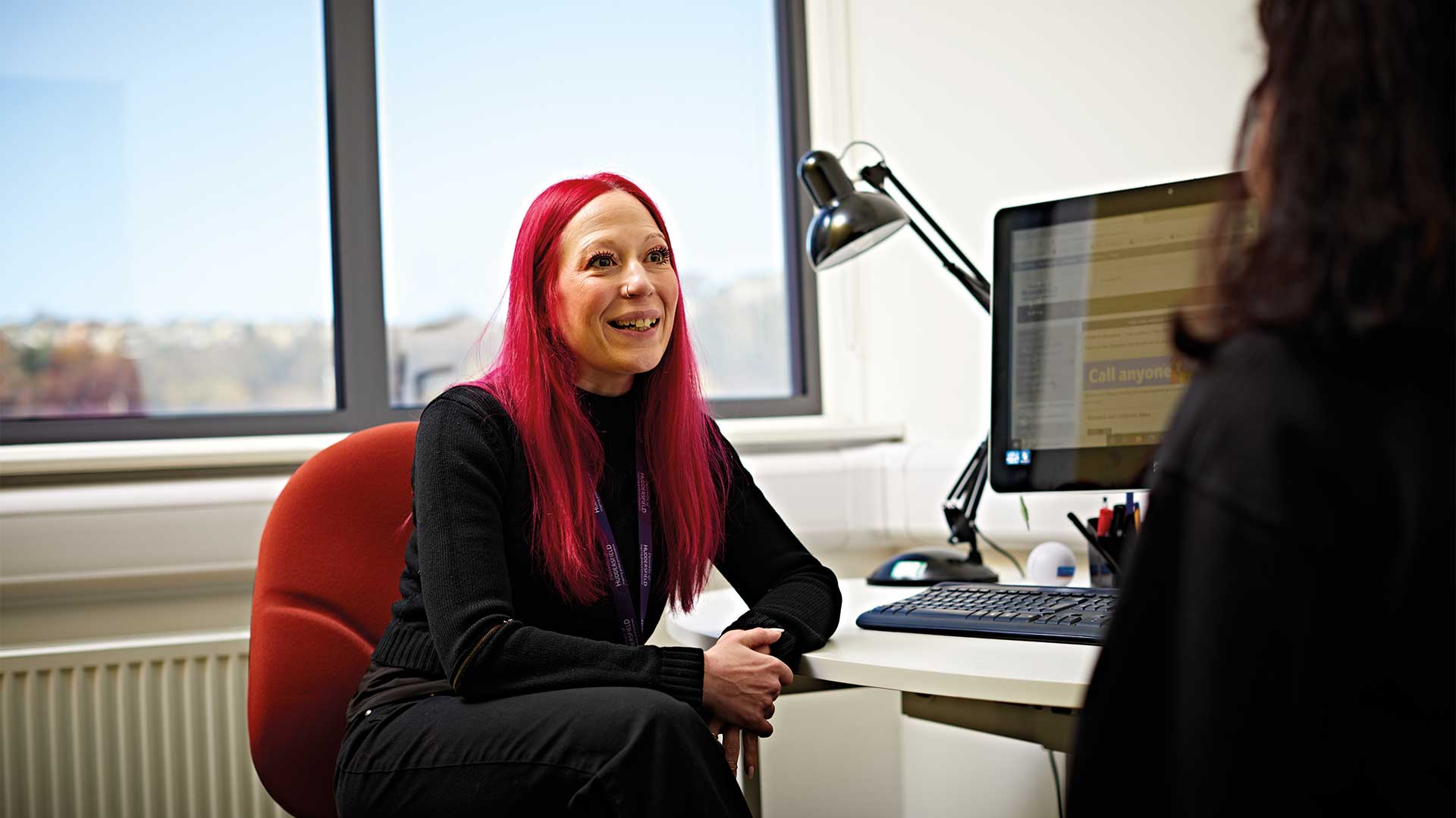 A student meets with a support worker in an advice room in Student Central