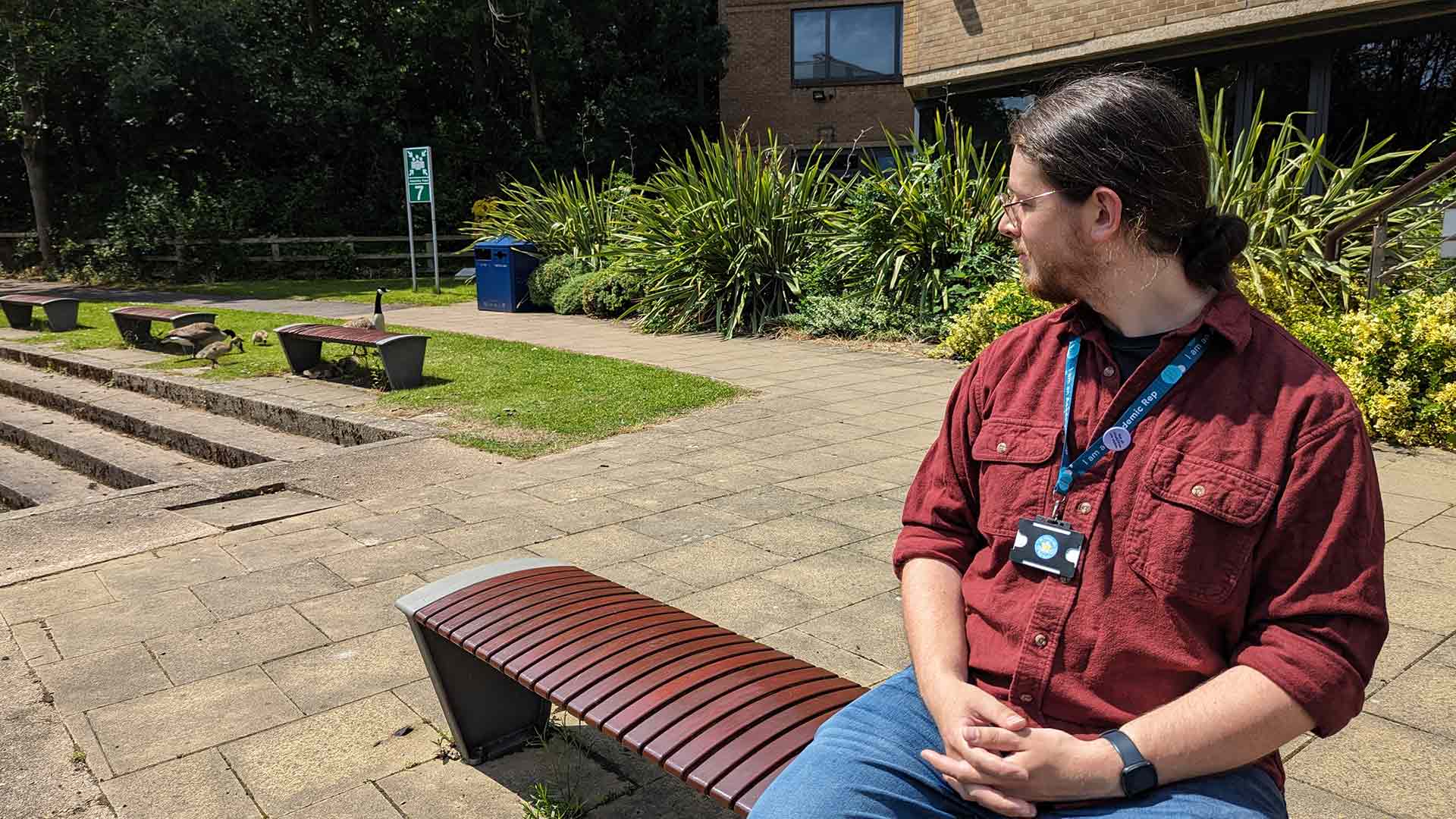 Joe sat on a bench by the campus canal, looking over into the distance.