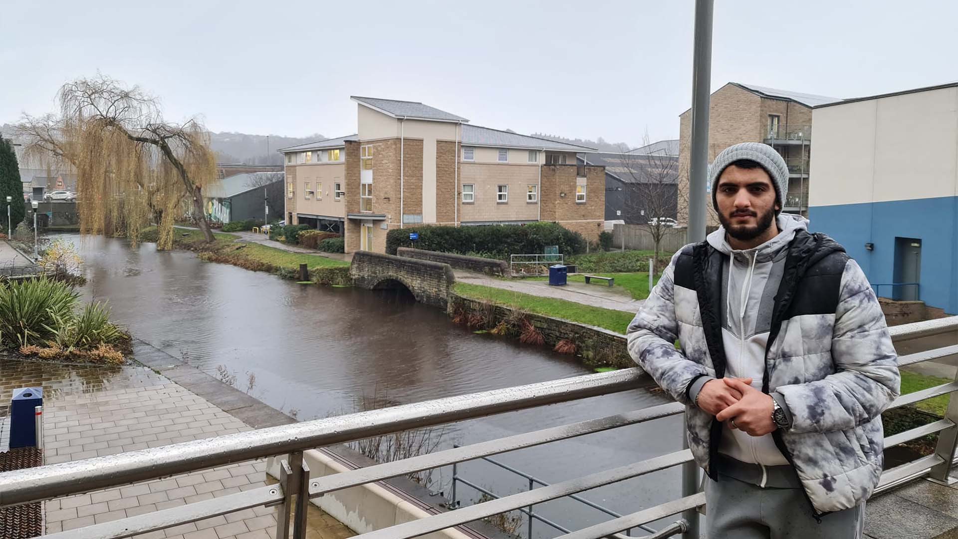 Saad Zahir standing on a bridge over the canal, on-campus.