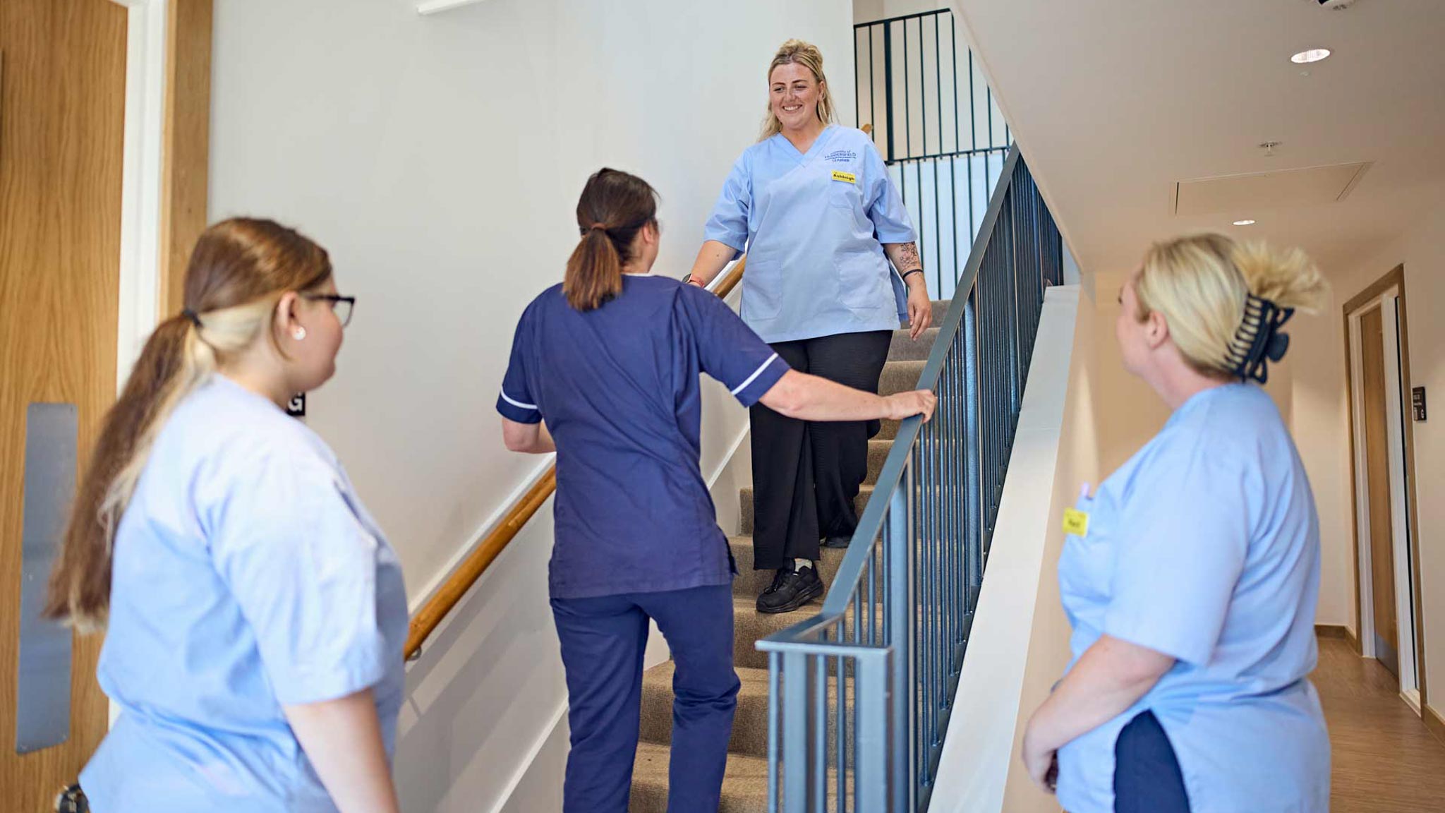 An occupational therapist demonstrates safe stair transfers to a student, preparing them for real-world practice.