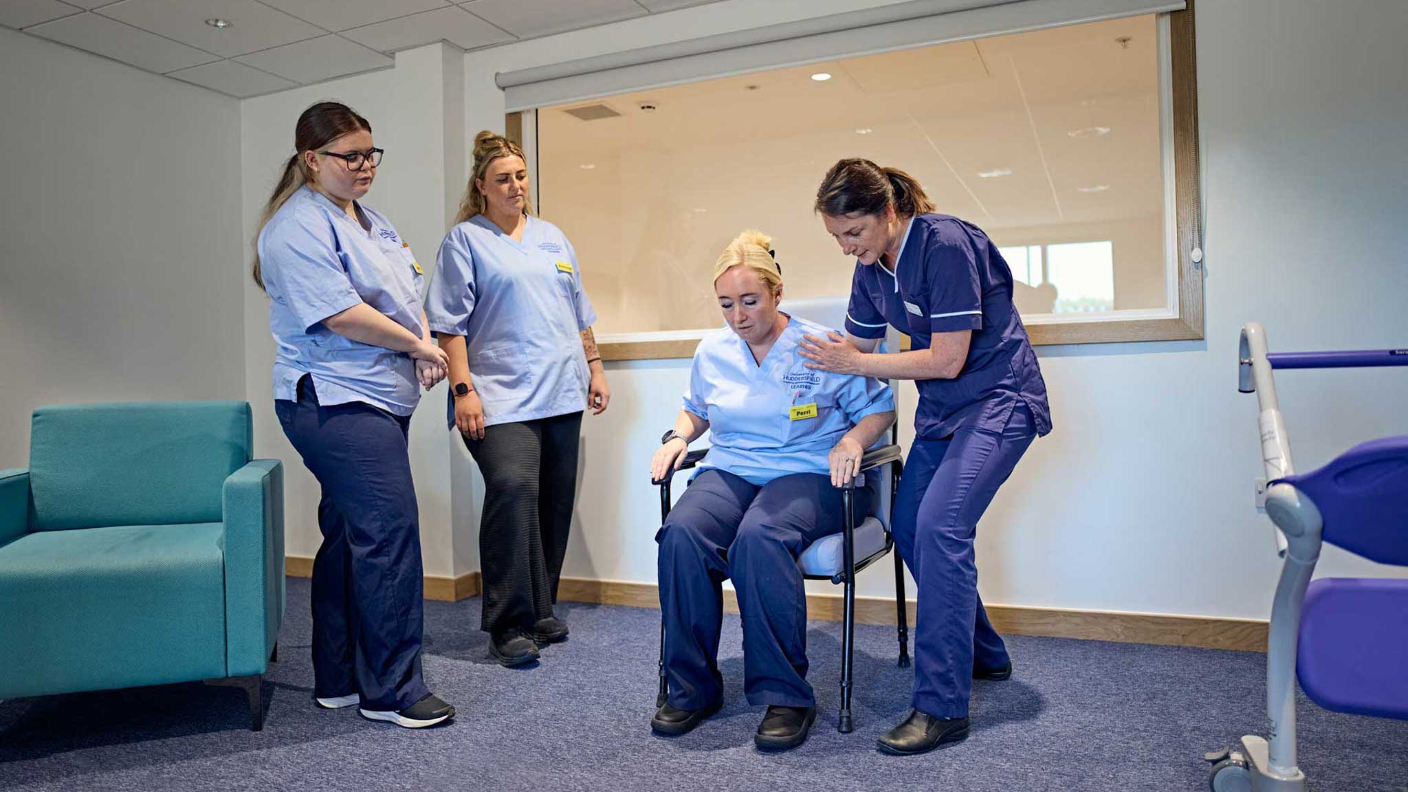 occupational therapist guides a student through safe sit-to-stand techniques.